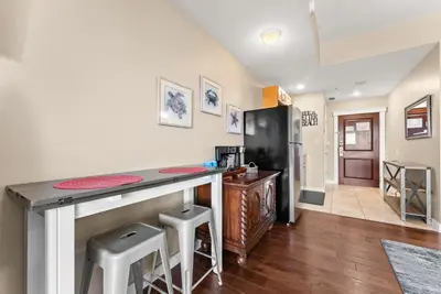 a kitchen with a counter and stools in a room at Origin 0525 - Studio King - Peaceful Nature View in Panama City Beach