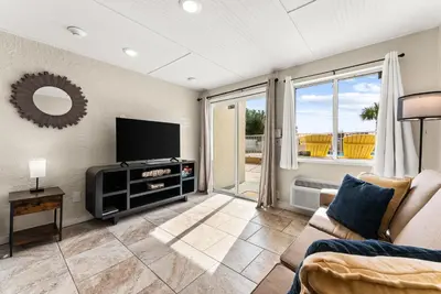 a living room with a tv and a couch at The Ambassador - Unit C5 - Studio King - On Pool Deck in Panama City Beach