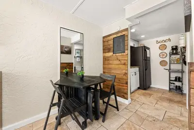 a dining room with a table and chairs and a refrigerator at The Ambassador - Unit C5 - Studio King - On Pool Deck in Panama City Beach