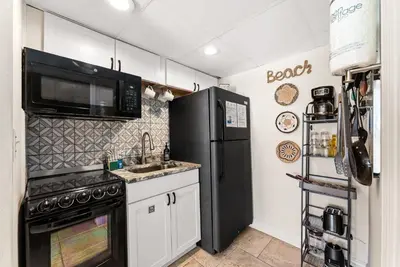 a kitchen with a black refrigerator and a sink at The Ambassador - Unit C5 - Studio King - On Pool Deck in Panama City Beach