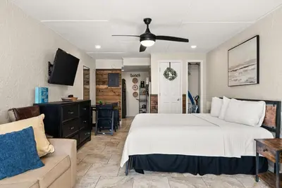 a bedroom with a large bed and a couch at The Ambassador - Unit C5 - Studio King - On Pool Deck in Panama City Beach
