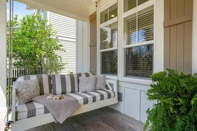 a porch with a couch and two windows at Driftwood - Vacation Home Near the Beach with a Large Outdoor Area in Santa Rosa Beach
