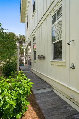 a house with a wooden walkway next to a building at Driftwood - Vacation Home Near the Beach with a Large Outdoor Area in Santa Rosa Beach