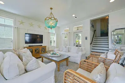 a living room with white furniture and a chandelier at Driftwood - Vacation Home Near the Beach with a Large Outdoor Area in Santa Rosa Beach