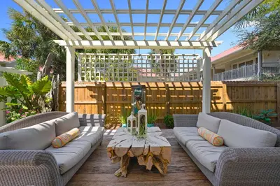 a patio with a couch and a table and a pergola at Driftwood - Vacation Home Near the Beach with a Large Outdoor Area in Santa Rosa Beach