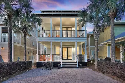 a large house with palm trees in front of it at Endless Summer Dream - Cottage Near the Beach with Shared Pool Access in Seacrest