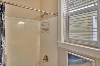 a bathroom with a shower and a window at Endless Summer Dream - Cottage Near the Beach with Shared Pool Access in Seacrest