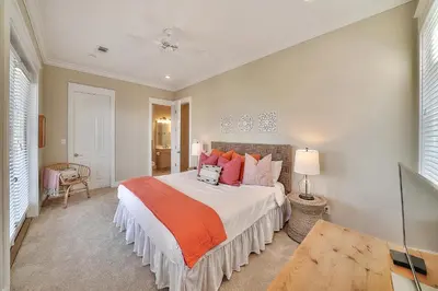 a bedroom with a large bed with orange pillows at Endless Summer Dream - Cottage Near the Beach with Shared Pool Access in Seacrest