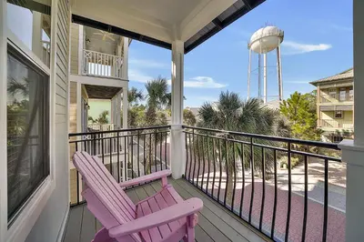 a porch with two purple chairs and a water tower at Endless Summer Dream - Cottage Near the Beach with Shared Pool Access in Seacrest