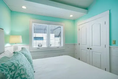 a bedroom with blue walls and a bed and a window at Gulf Escape - 30A Beach House Near the Beach with a Large Pool Space in Inlet Beach