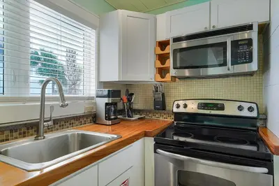a kitchen with a sink and a stove and a microwave at Gulf Escape - 30A Beach House Near the Beach with a Large Pool Space in Inlet Beach