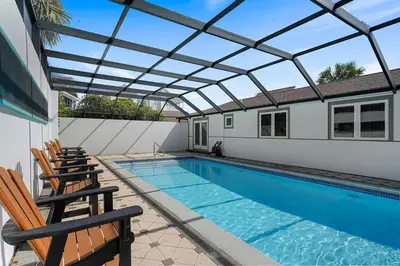 a swimming pool with chairs and a glass roof at Gulf Escape - 30A Beach House Near the Beach with a Large Pool Space in Inlet Beach