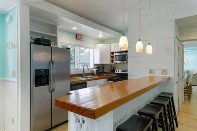 a kitchen with a wooden counter and a refrigerator at Gulf Escape - 30A Beach House Near the Beach with a Large Pool Space in Inlet Beach