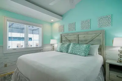 a bedroom with a bed with blue walls and a window at Gulf Escape - 30A Beach House Near the Beach with a Large Pool Space in Inlet Beach