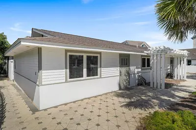 a small white house with a palm tree at Gulf Escape - 30A Beach House Near the Beach with a Large Pool Space in Inlet Beach