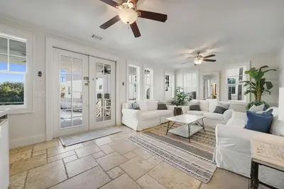 a living room with white furniture and a ceiling fan at Hermosa Manor - Luxury Vacation Rental House Near the Beach with Private Pool Area & Gulf Views in Santa Rosa Beach