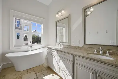 a bathroom with a tub and a sink and a mirror at Hermosa Manor - Luxury Vacation Rental House Near the Beach with Private Pool Area & Gulf Views in Santa Rosa Beach