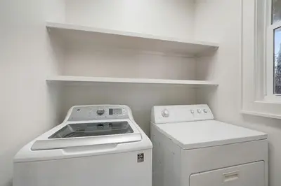 a kitchen with a stove and a washer and dryer at Hermosa Manor - Luxury Vacation Rental House Near the Beach with Private Pool Area & Gulf Views in Santa Rosa Beach