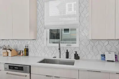 a white kitchen with a sink and a window at Sea Grove - Beachfront, Ocean Views & Balcony in Santa Rosa Beach