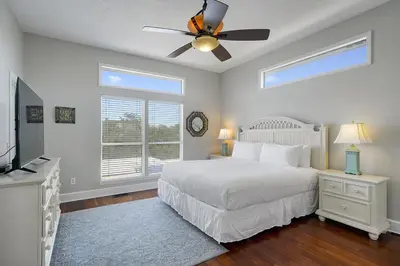 a bedroom with a white bed and a ceiling fan at Inlet Getaway - Luxury Vacation Rental Near the Beach with Private Pool Area & Gulf Views in Seacrest