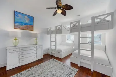 a bedroom with two bunk beds and a ceiling fan at Inlet Getaway - Luxury Vacation Rental Near the Beach with Private Pool Area & Gulf Views in Seacrest