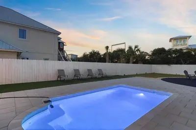 a large blue swimming pool in a backyard at Inlet Getaway - Luxury Vacation Rental Near the Beach with Private Pool Area & Gulf Views in Seacrest