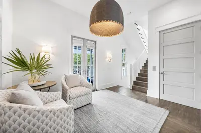 a living room with a couch and two chairs at YOLO Cottage in Rosemary Beach