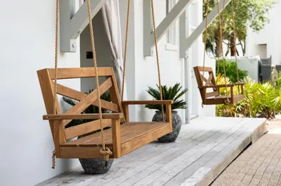 a swing on the porch of a house at YOLO Cottage in Rosemary Beach