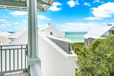 a balcony with a view of the ocean at YOLO Cottage & Carriage in Rosemary Beach
