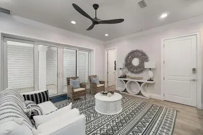 a living room with a white couch and a ceiling fan at Restoration Point in Santa Rosa Beach