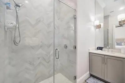 a shower with a glass door in a bathroom at Restoration Point in Santa Rosa Beach