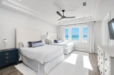 a white bedroom with two beds and a window at Restoration Point in Santa Rosa Beach
