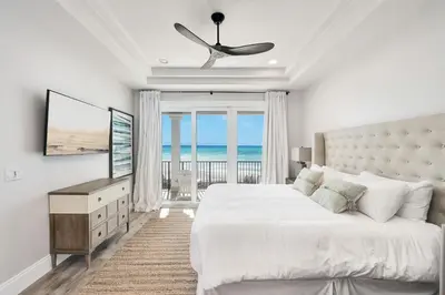 a bedroom with a bed and a view of the ocean at Restoration Point in Santa Rosa Beach