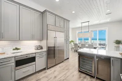 a kitchen with a stainless steel refrigerator and a dining room at Restoration Point in Santa Rosa Beach