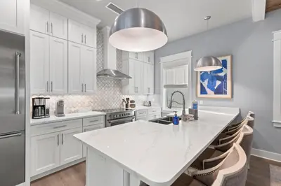 a kitchen with white cabinets and a large white island at 30A Pet Friendly Beach House - Scissortrail at Treetops in Seacrest