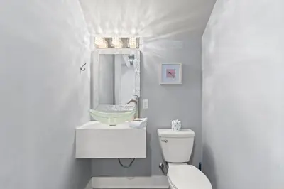 a white bathroom with a sink and a toilet at 30A Pet Friendly Beach House - Scissortrail at Treetops in Seacrest