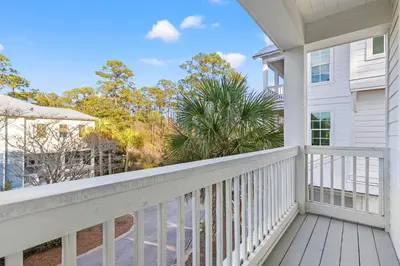 a white house with a balcony with trees at 30A Pet Friendly Beach House - Scissortrail at Treetops in Seacrest