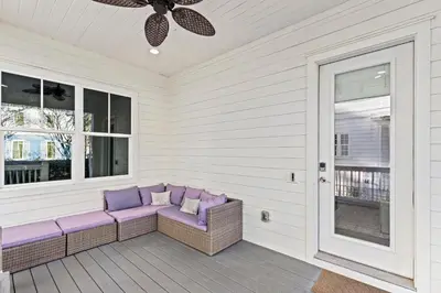 a porch with a purple couch and windows at 30A Pet Friendly Beach House - Scissortrail at Treetops in Seacrest