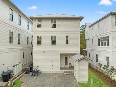 a large white house with a courtyard between two buildings at 30A Pet Friendly Beach House - Scissortrail at Treetops in Seacrest