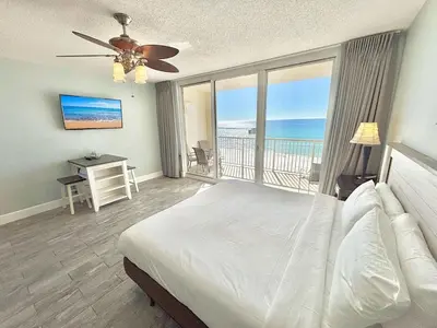 a bedroom with a bed and a view of the ocean at Beachfront Studio with Bunks Sleeps 4 at Majestic! in Panama City Beach