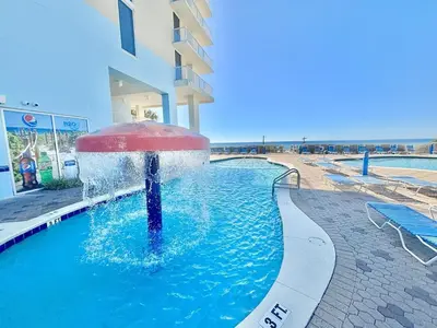 a pool with a fountain in the middle of a building at Beachfront Studio with Bunks Sleeps 4 at Majestic! in Panama City Beach