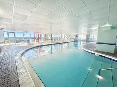 a large swimming pool in a building at Beachfront Studio with Bunks Sleeps 4 at Majestic! in Panama City Beach