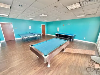 a room with a pool table and two tables at Beachfront Studio with Bunks Sleeps 4 at Majestic! in Panama City Beach