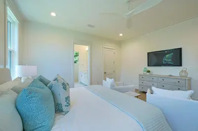 a bedroom with a white bed with blue pillows at Pompano Paradise - 30A Vacation House with Ocean Views, Private Pool & Golf Cart in Rosemary Beach