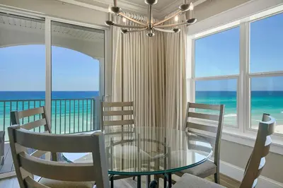 a dining room with a glass table and chairs and the ocean at Seaview 1 Unit 300 - Gulf Front Condo on 30A & Ocean Views in Santa Rosa Beach