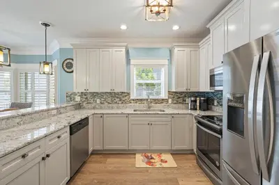 a kitchen with white cabinets and a stainless steel refrigerator at Southern Charm - Luxury Vacation Rental Near the Beach with Community Pool & Amenities in Seacrest