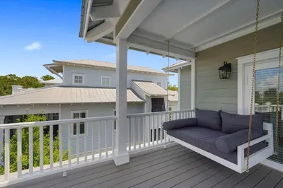 a porch swing with a couch on a house at Southern Charm - Luxury Vacation Rental Near the Beach with Community Pool & Amenities in Seacrest