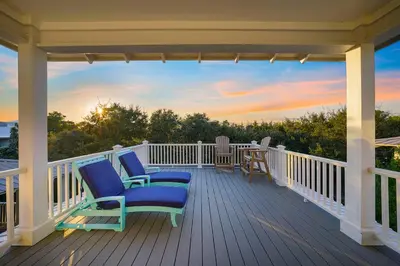 a porch with two chairs and a sunset at Southern Charm - Luxury Vacation Rental Near the Beach with Community Pool & Amenities in Seacrest