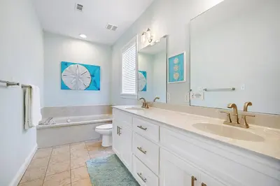 a bathroom with a sink and a toilet and a mirror at The Sassy Seagull - 30A Beach House with Ocean Views in Seacrest