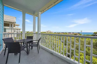 a porch with a table and chairs and the ocean at The Sassy Seagull - 30A Beach House with Ocean Views in Seacrest